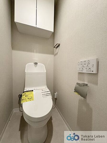 ウォシュレット機能付きのトイレは壁掛けリモコンの上位グレードを採用。便座がスッキリした印象となり、限られた空間を広く見せる効果があります。