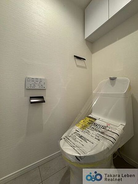 ウォシュレット機能付きのトイレは壁掛けリモコンの上位グレードを採用。便座がスッキリした印象となり、限られた空間を広く見せる効果があります。