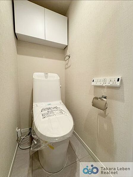 ウォシュレット機能付きのトイレは壁掛けリモコンの上位グレードを採用。便座がスッキリした印象となり、限られた空間を広く見せる効果があります。