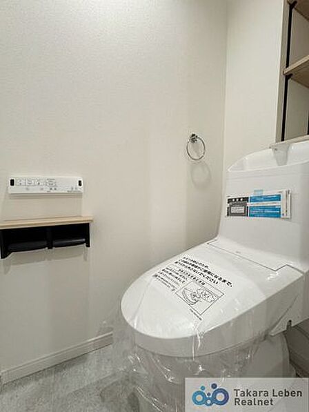 ウォシュレット機能付きのトイレは壁掛けリモコンの上位グレードを採用。便座がスッキリした印象となり、限られた空間を広く見せる効果があります。