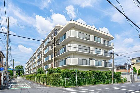 白を基調とした清潔感のある外観デザインと、敷地周りに手入れされた豊かな植栽のグリーンが映える落ち着いた住環境です。