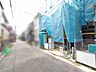 外観：完成に向かう街並みに佇み、新しい暮らしの始まりを静かに予感させる穏やかな景色。