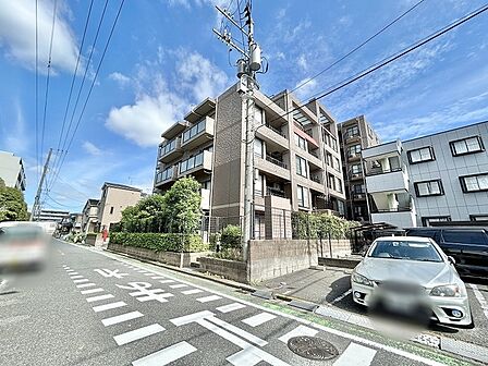 青空の下に佇む落ち着いた色合いの外観が周囲の街並みに心地よく調和します