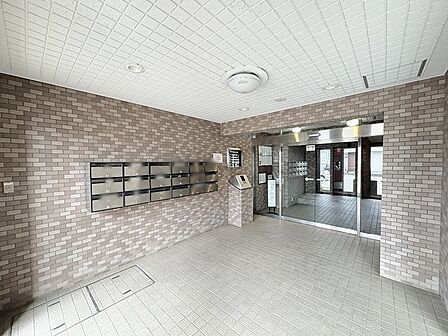 落ち着いた色合いのタイルが織りなす、安心感のある上品なエントランス空間