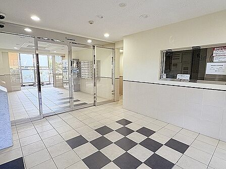 洗練されたタイル貼りの床面とガラス張りの建具が織りなす清潔感に満ちた空間