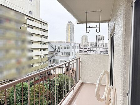 都市の空が広がる開放的なバルコニーから心地よい風が通り抜けます