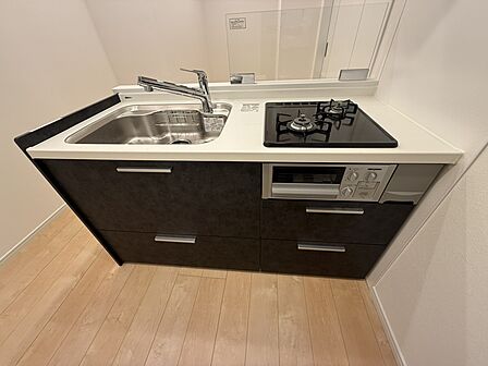 【キッチン】2026年3月に新規交換済みのシステムキッチン。2口ガスコンロで並行調理が可能です。奥にしまった物を取り出しやすい、スライド式収納付き。