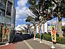 その他：広々とした空の下、街路樹が彩る歩道。イベントを告知する旗が並び、賑わいを感じさせる街並みです。都心でありながら自然も身近な暮らしを提案します。