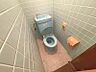 トイレ：淡いブルーのタイルとトイレが特徴的な空間です。清潔感があり、快適にお使いいただけます。