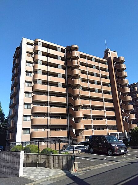 青空に映えるブラウンの外観が特徴的なマンションです。落ち着いた雰囲気で、新生活を始める方に寄り添います。