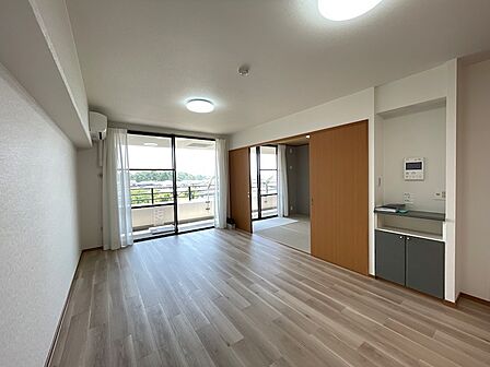 明るい日差しが差し込むリビングは、木目調のフローリングが心地よい空間を演出します。隣接する和室は、来客時や寛ぎのスペースとしても活用できます。