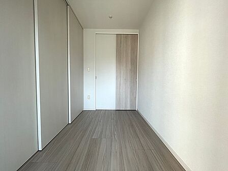 木目調の床と白い壁が調和した居室は、明るく清潔感のある空間です。大きな収納も備え、ゆとりのある暮らしをサポートします。