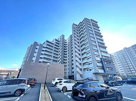 青空に映えるスタイリッシュな外観のマンション。敷地内駐車場を完備し、快適なカーライフをサポートします。