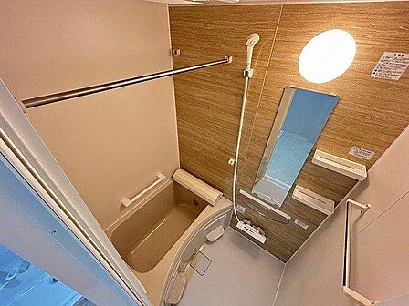 木目調の壁が落ち着いた印象の浴室。コンパクトながらも必要な設備が整っており、一日の疲れを癒す空間です。