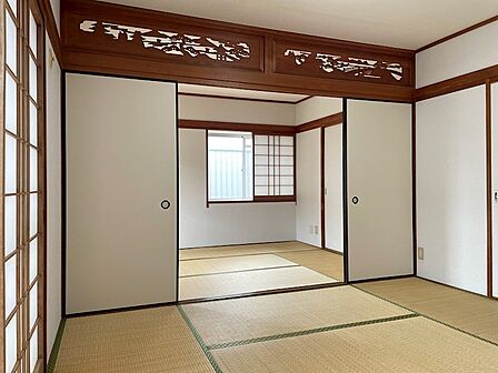 趣のある彫刻欄間が目を引く和室。障子からやわらかな光が差し込み、畳の香りが心地よい空間です。