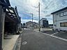 外観：現地を撮影した画像です。周辺には住宅や店舗、駐車場があり、生活に必要な施設が揃っています。