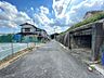 その他：建築中の物件が確認できます。前面道路は舗装されており、周辺には住宅が点在するエリアです。