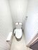 トイレ：清潔感のあるストライプのクロスとマーブル模様の床が特徴のトイレ空間。ウォシュレット付きで、快適な毎日をサポートします。飾り棚やタオルリングも完備。