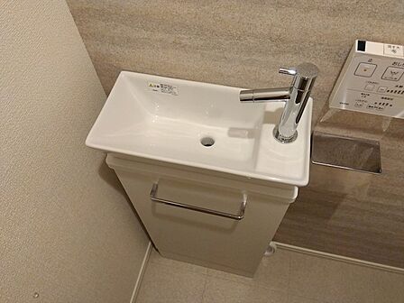 トイレ内に設置された手洗い器。コンパクトながらも使いやすく、来客時にも便利です。清潔感あふれる空間を演出します。