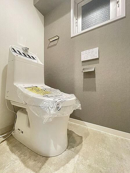 機能的な温水洗浄便座を設置したトイレは、窓から自然光が差し込み、明るく快適な空間です。日々の生活をより豊かにします。