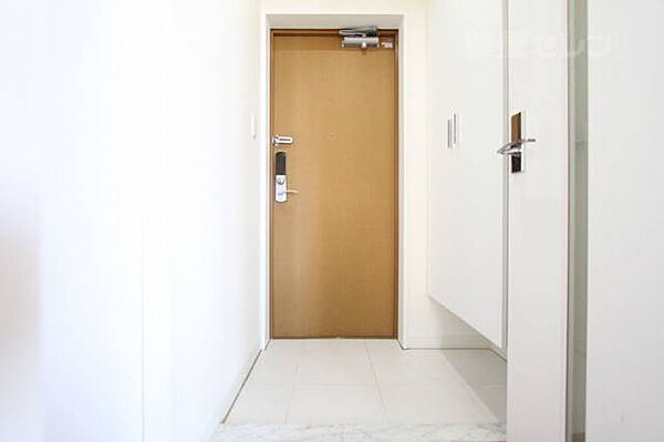 画像7:タイルまで真っ白な玄関にブラウンの扉！