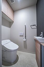 吊り戸棚を設けたトイレです。温水洗浄便座付で快適にご使用いただけます。また手洗い場も設置されています