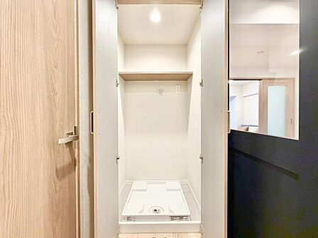 扉付きの洗濯機置き場。生活感をすっきり隠せる便利な設計です。