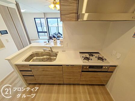 木目調のパネルが落ち着いた雰囲気を醸し出すシステムキッチン。リビングを見渡せるオープンな設計なので、家族との会話を楽しみながら毎日のお料理をゆとりを持って進めることができます