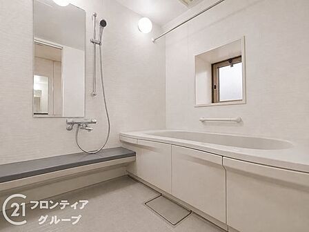 白を基調とした清潔感あふれる浴室です。ゆったりとした浴槽は一日の疲れを癒やすのに最適で、窓があるため開放感も感じられます。手すり付きの安心設計で、家族全員が快適に利用できます