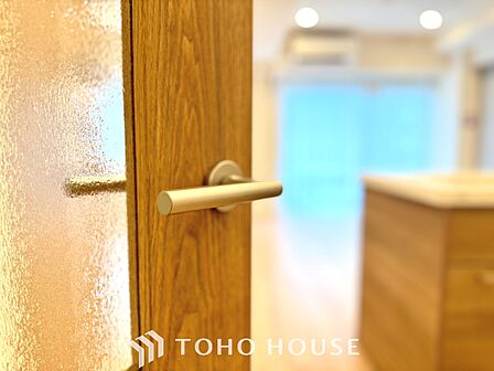 【Decorative lighting】 上質に仕上げられた室内。オフ・ホワイトの壁を背にした観葉植物の葉をそっと置かれたインテリア・ライトが照らし出しています。少しお洒落な暮らしをしてみませんか。