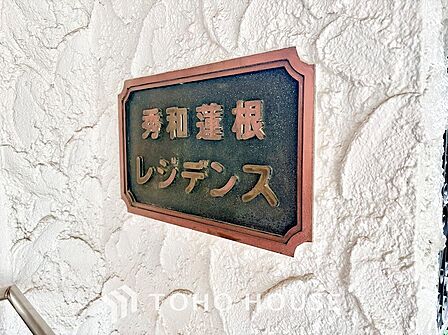 凹凸感が重厚な割り肌調タイルに掲げられた「シティテラス板橋蓮根」のステンレス切り文字サイン。青々とした植栽に映える格調高いエンブレムが、住まい手のステータスと所有欲を満たします。