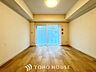 室内：【Decorative lighting】上質に仕上げられた室内。オフ・ホワイトの壁を背にした観葉植物の葉をそっと置かれたインテリア・ライトが照らし出しています。少しお洒落な暮らしをしてみませんか。