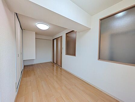 木目調フローリングと白壁が爽やかな洋室です。壁面には廊下や他室からの採光を取り込める室内窓を設置。クローゼット収納に加え引き戸を採用しており、限られたスペースを有効活用できる使いやすい室内設計です。
