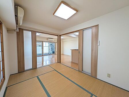 和室からリビング・キッチン方向を見渡したショットです。引き戸を開放することで風と光が部屋全体を行き交い、開放感あふれる一続きの空間に。暮らしのシーンに合わせてフレキシブルに空間を区切れます。