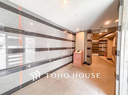 住まう誇らしさと安心感を演出する落ち着いた雰囲気のエントランス。
