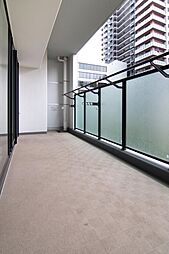 視線を遮るパネル付きのバルコニーで、周囲を気にせず洗濯物を干せる設計。奥行きがあり、日常使いしやすい屋外スペースです。現地（2025年11月）撮影