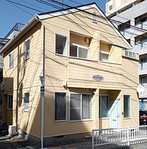 外観：二階建ての黄色いアパートです