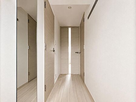 明るい木目調で統一された室内廊下。玄関から居室まで、清潔感のある落ち着いた印象です。