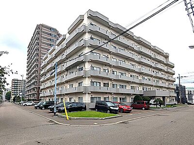 外観：落ち着いたベージュを基調とした、清潔感のある佇まい。角地に建つため日当たりが良く、前面道路も広々としています！敷地内には便利な平面駐車場も完備。長く愛される、安定感のある住まいです。