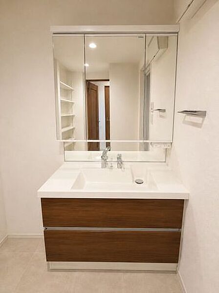 ※居住中の為、家具を消す画像処理を施しております。大きな三面鏡を備えた洗面化粧台。木目調の収納がアクセントとなった、上質感のある水まわりです。