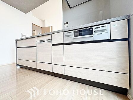 作業しやすいゆとりあるシステムキッチン。シンプルな配色で飽きずに使い続けることができます。