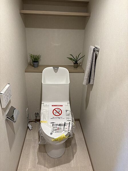 ホワイトを基調としたトイレは清潔感がございます。上部に棚があり、掃除用品の収納にも便利です。