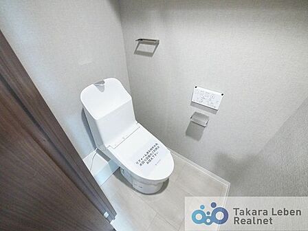 ウォシュレット機能付きのトイレは壁掛けリモコンの上位グレードを採用。便座がスッキリした印象となり、限られた空間を広く見せる効果があります。