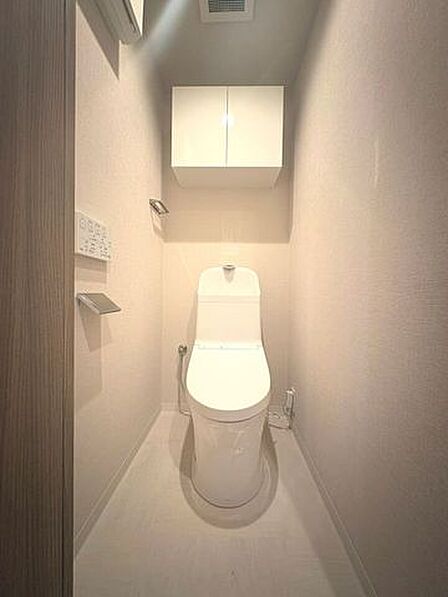 温水洗浄便座付きの清潔なトイレ。上部収納もあり、生活用品をすっきり整理できます。
