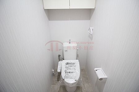 上部収納と温水洗浄便座を備えた快適なトイレ空間