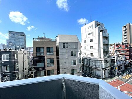 バルコニーからの眺望。前面は低層住宅中心で、開放感のある景色が広がります。晴れた日は青空が心地よく感じられます。