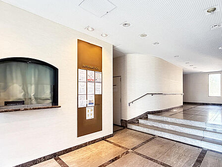【エントランス】管理員室の窓口と掲示板が並ぶエントランス。数段の階段には手すりが付き、上がり下りも安心です。