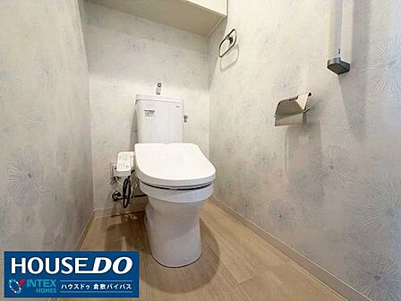 【清潔感たっぷりの落ち着くトイレ空間！】上品なクロス柄と明るい木目調床材がおしゃれな雰囲気を演出♪上部吊戸棚にはトイレットペーパーなどを隠してすっきり収納でき、毎日快適に使えますね！