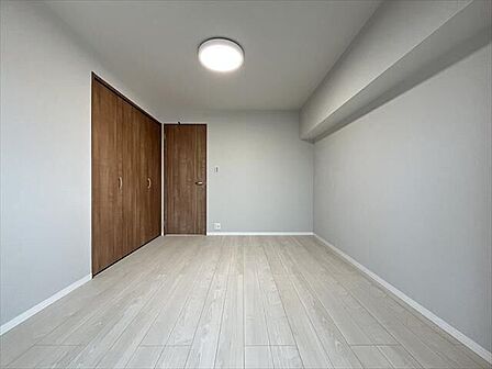 6帖南東側:白を基調とした内装に木目の建具が映える、シンプルで落ち着いた空間です。家具のレイアウトもしやすく、寝室や子ども部屋など幅広く活用できます。
