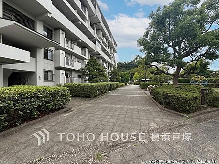 【敷地内通路】住棟を結ぶように伸びる団地内の通路。整然とした建物と豊かな植栽が織りなす景観から、ゆったりとした時間が流れる住環境を感じられます。